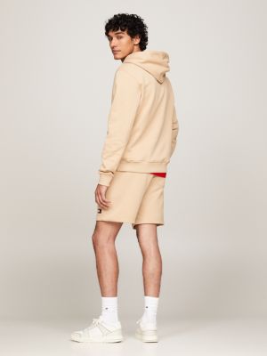 beige tommy badge hoodie mit tunnelzug für herren - tommy jeans