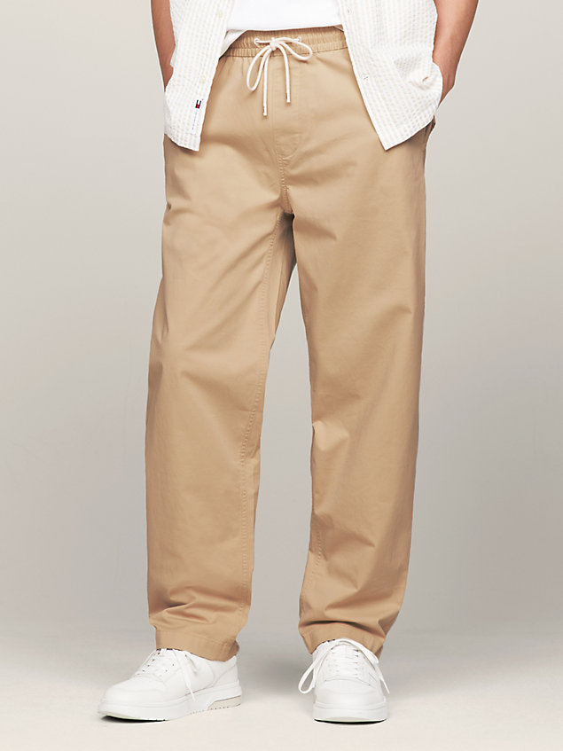 pantalón aiden informal de corte cónico beige de hombres tommy jeans